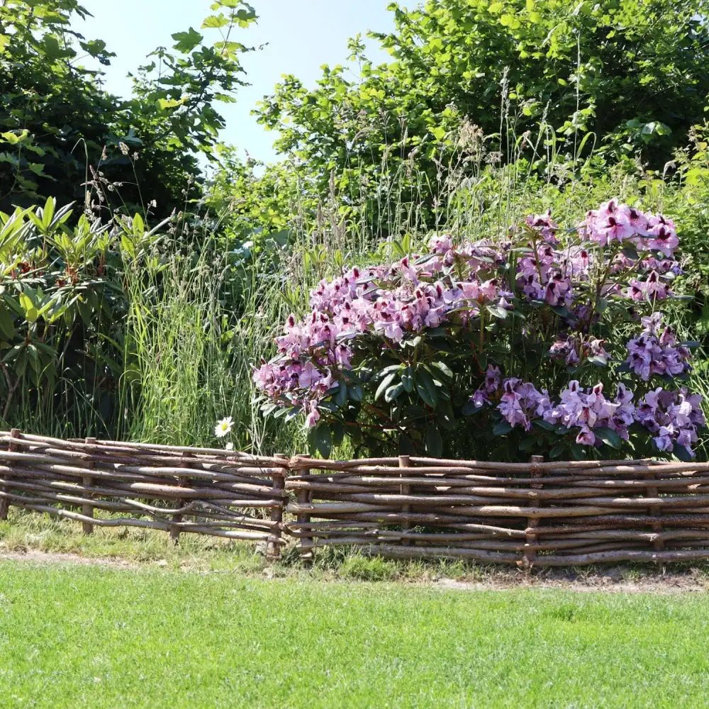 Woven hazel hurdles forming a soft boundary between the park and the neighbouring lane.