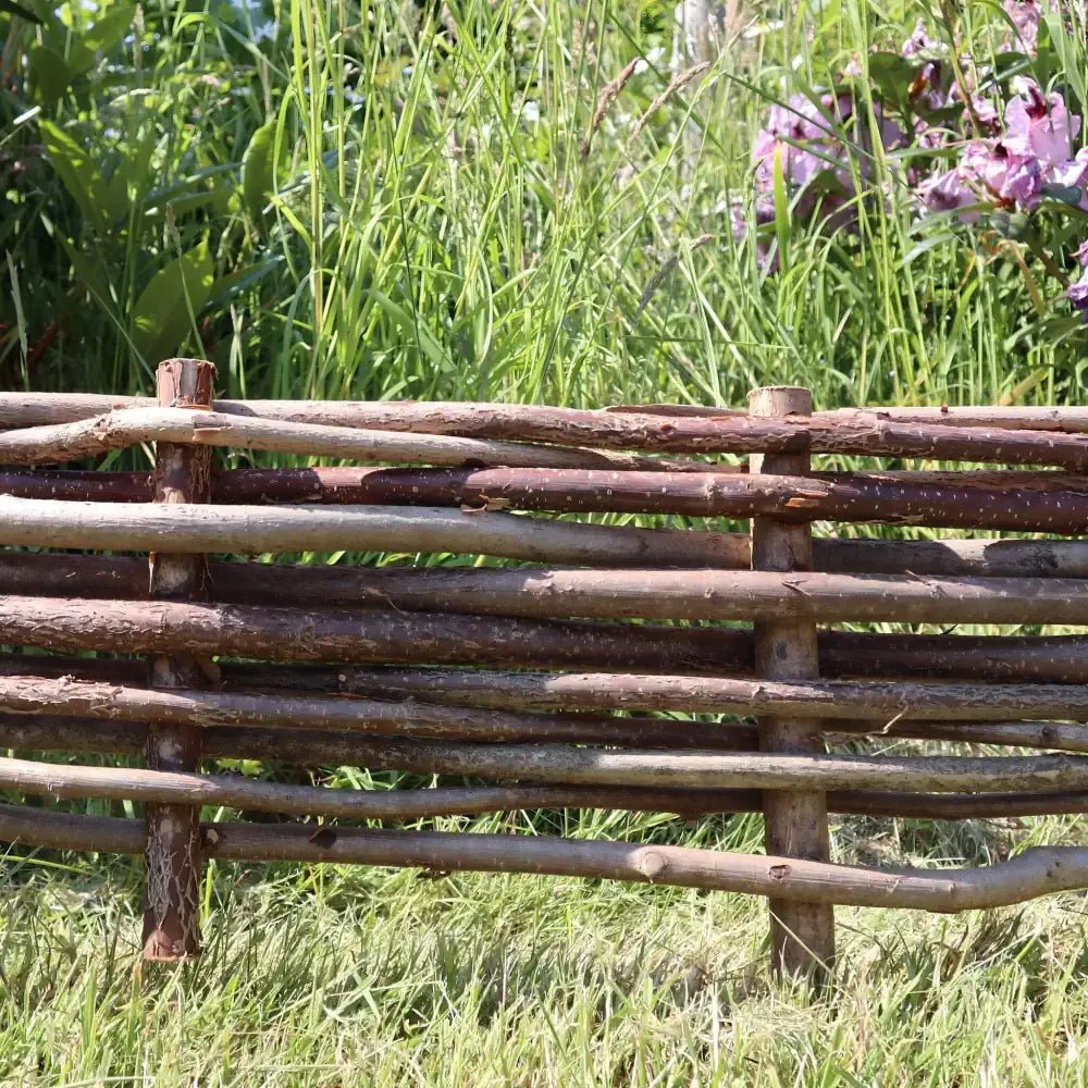 Woven hazel hurdles forming a soft boundary between the park and the neighbouring lane.