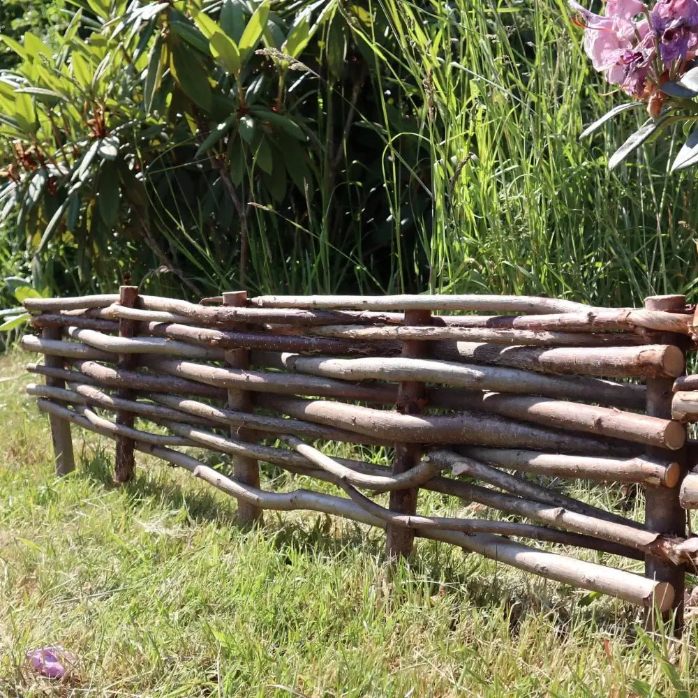 Woven hazel hurdles forming a soft boundary between the park and the neighbouring lane.