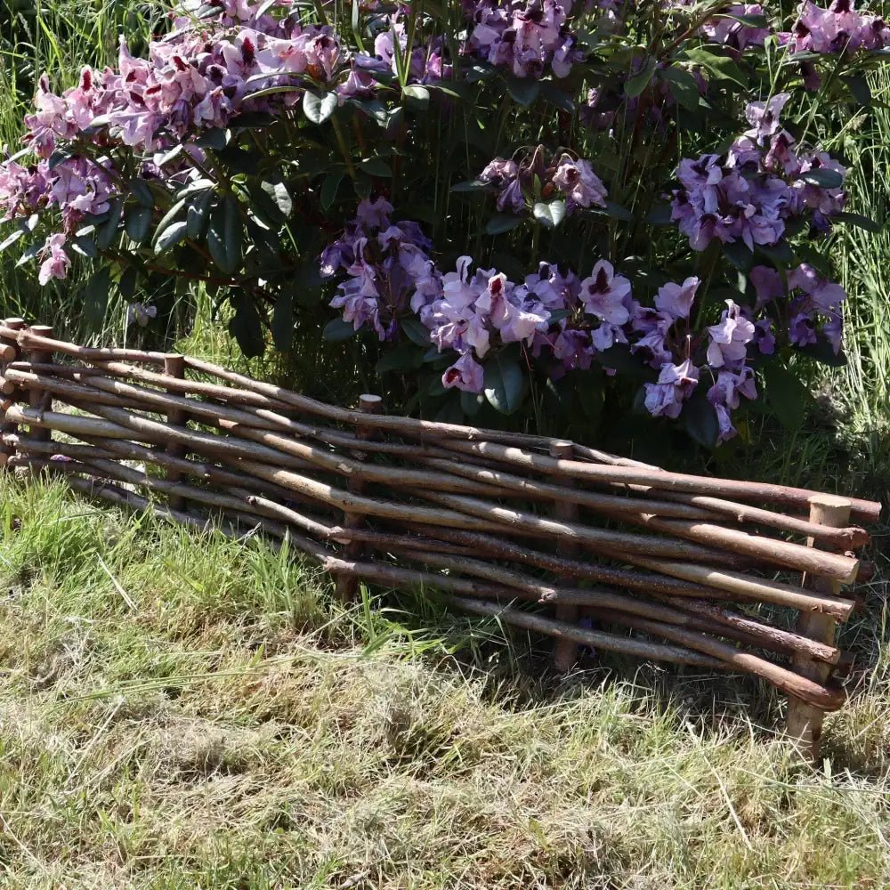 Woven hazel hurdles forming a soft boundary between the park and the neighbouring lane.